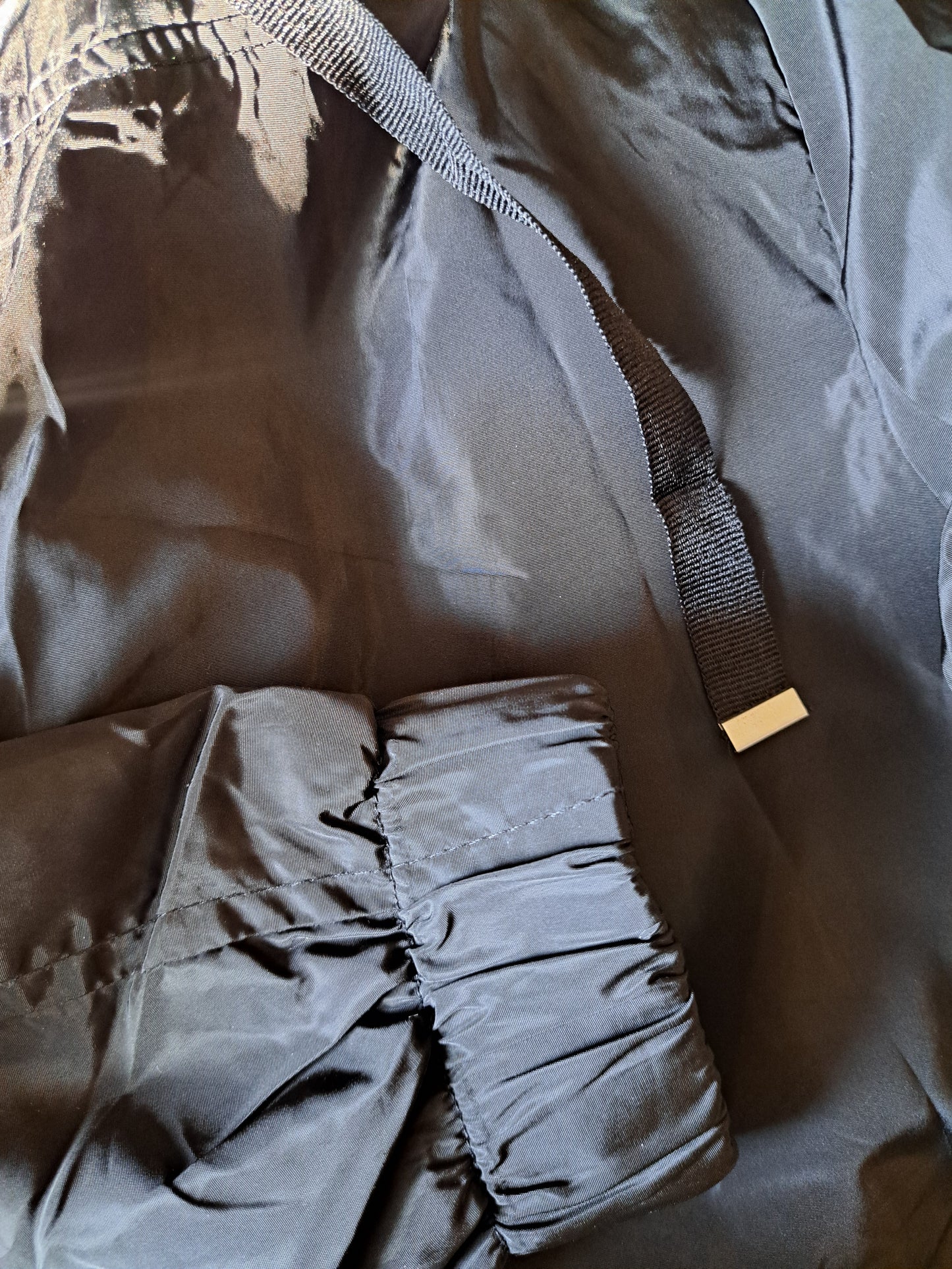Manteau de printemps noir avec capuchon ajustable dans le bas