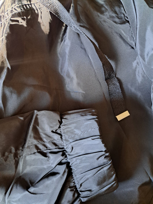 Manteau de printemps noir avec capuchon ajustable dans le bas