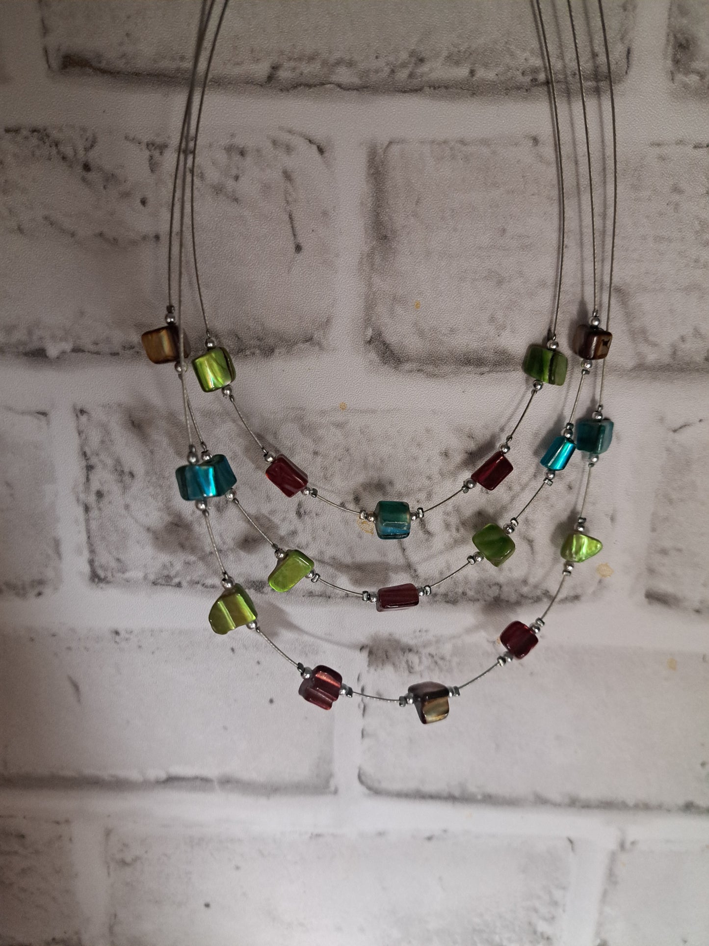 Collier en fils de pêche avec pierres rouges, vertes et bleues