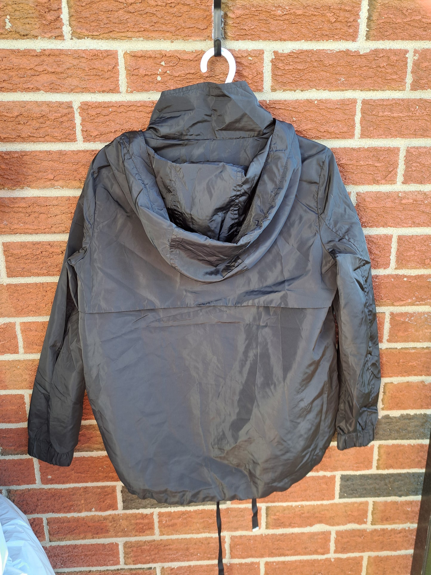 Manteau de printemps noir avec capuchon ajustable dans le bas