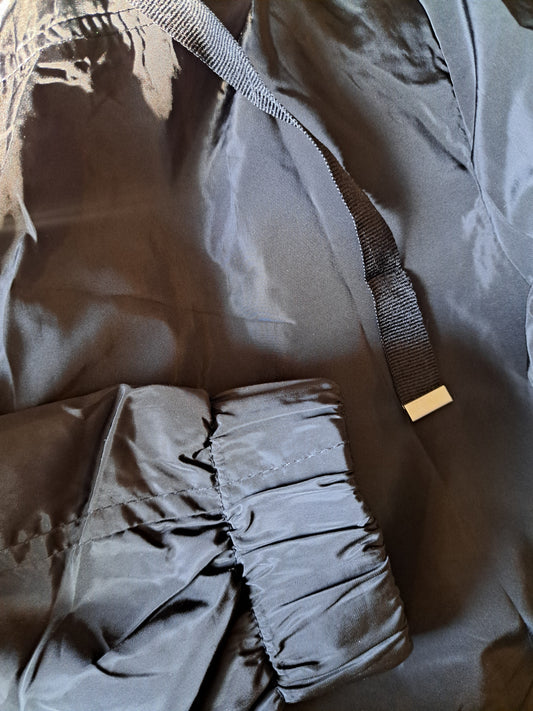 Manteau de printemps noir avec capuchon ajustable dans le bas