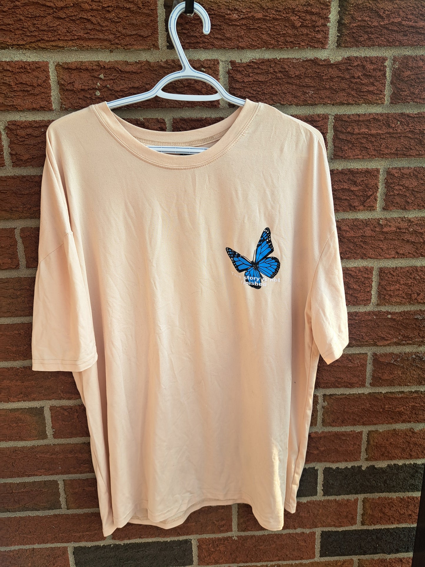 T-shirt beige avec papillon bleu