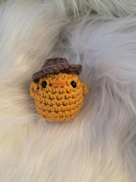 Petit poussin jaune avec chapeau tricoté à la main