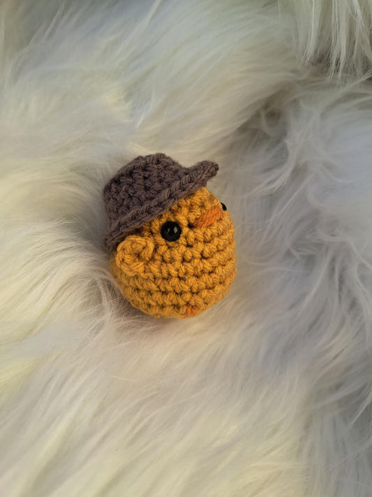 Petit poussin jaune avec chapeau tricoté à la main